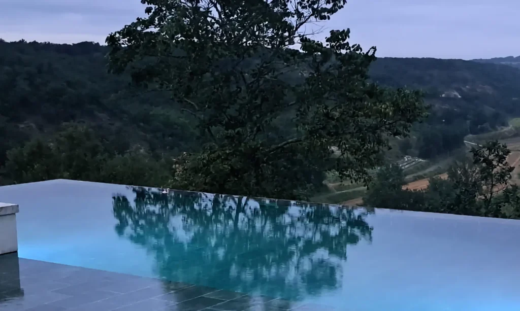 Piscine à débordement carrelée construite soi-même sur un terrain en pente, en France