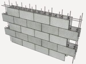 Montage d’un mur de piscine en blocs à bancher avec ferraillage intégré.