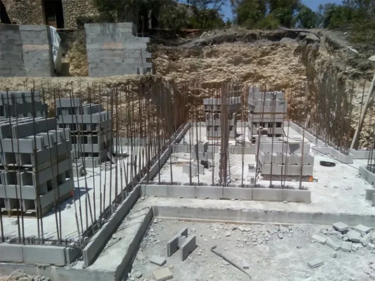 Photo montrant la mise en place du ferraillage des murs de piscine avec des blocs à bancher