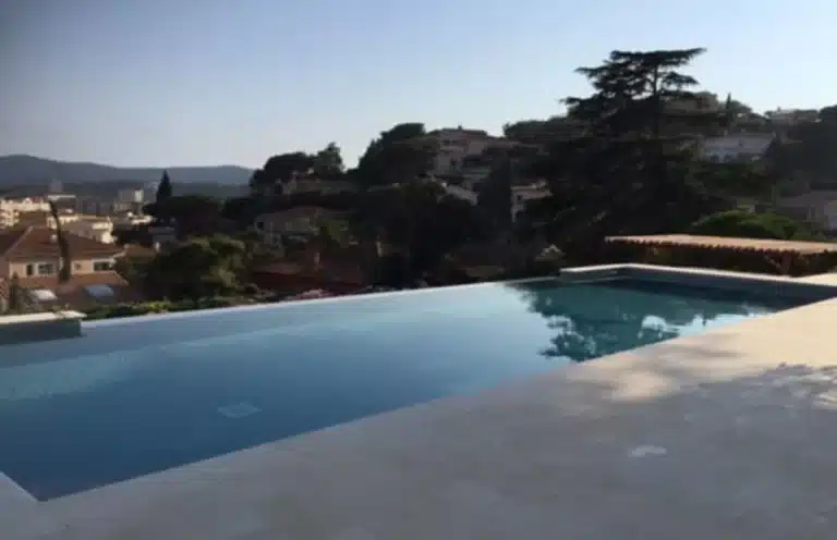 Piscine à débordement sur une partie de la longueur pour ouvrir sur la vue dégagée.
