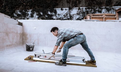 Homme entrain d'autoconstruire sa piscine grâce à des plans de piscine professionnels