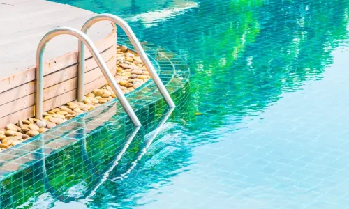Piscine avec eau limpide reflétant la lumière, symbole d’un circuit hydraulique bien conçu